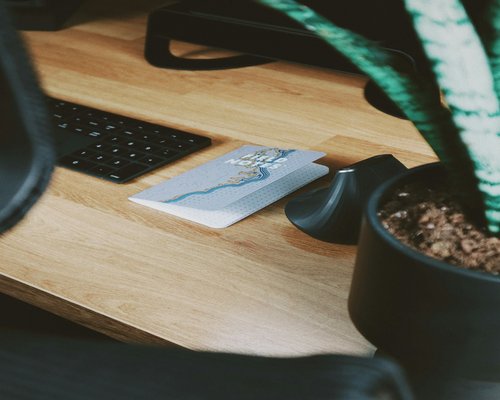 A glass of pure mineral water on a working wooden desk next to a notebook